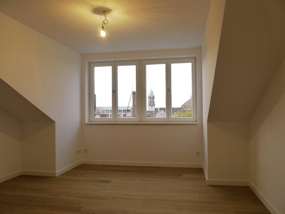 In der Ecke des Zimmers befindet sich ein großes Fenster.