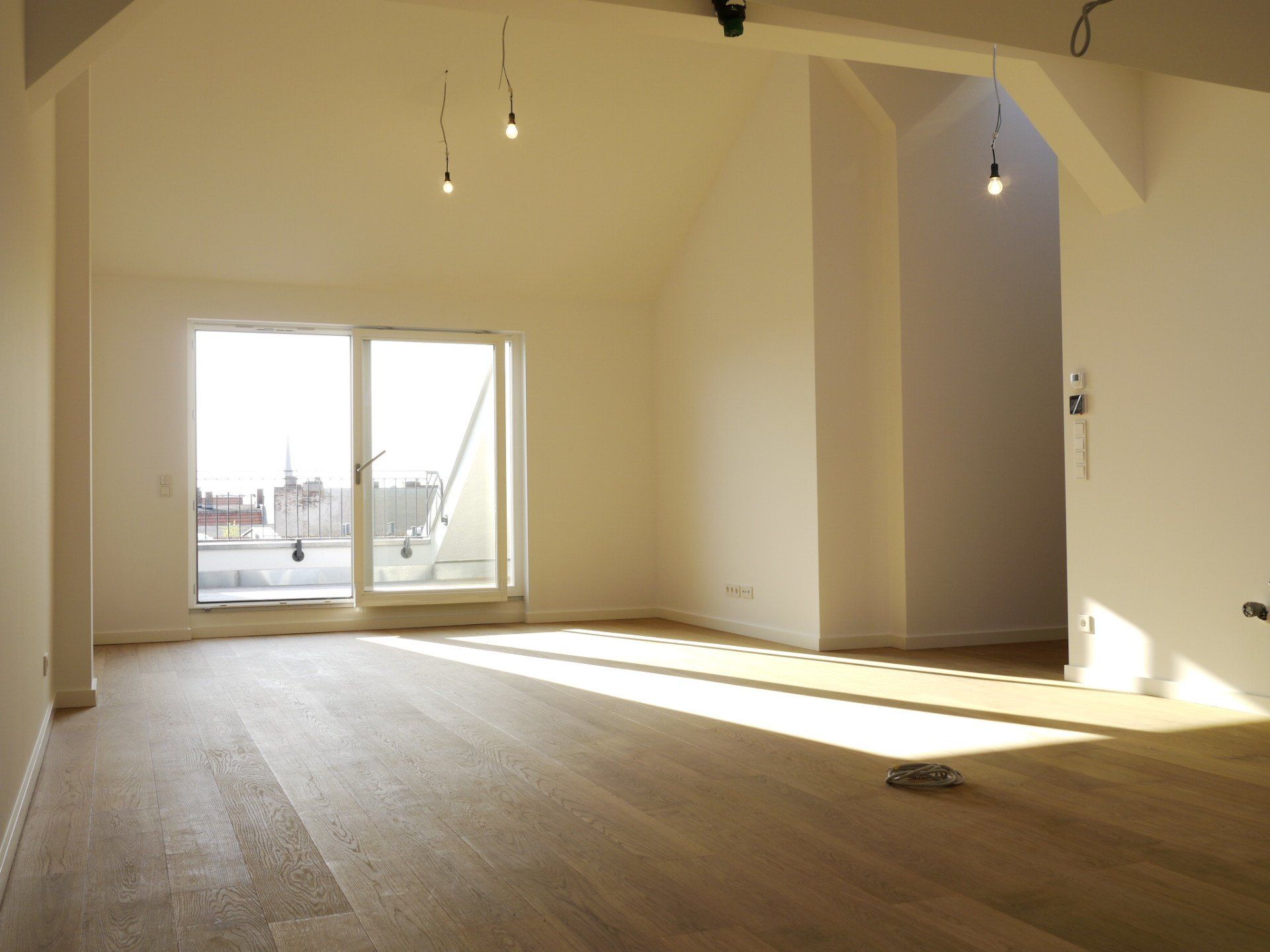 Ein leerer Raum mit Hartholzböden und weißen Wänden