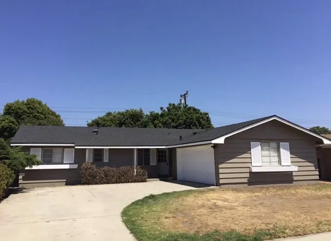 A house with a black roof and a white garage door.