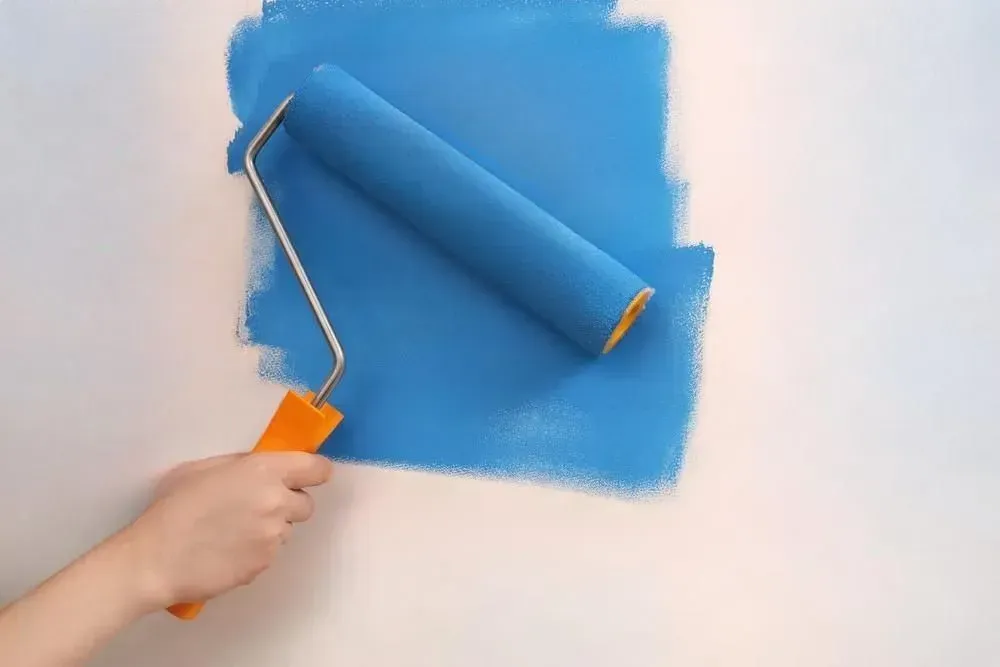 A man is working on a wall in a room.