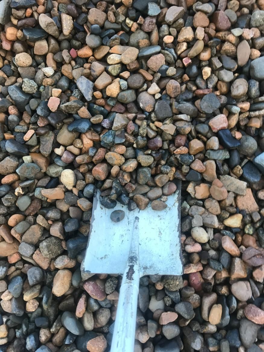 A Shovel is Sitting on Top of a Pile of Rocks — Chooks Sand And Gravel In Paget, QLD