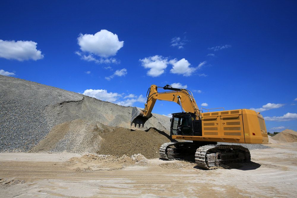 Yellow Excavator Scooping up Sand at a Construction Site — Chooks Sand And Gravel In Bowen, QLD