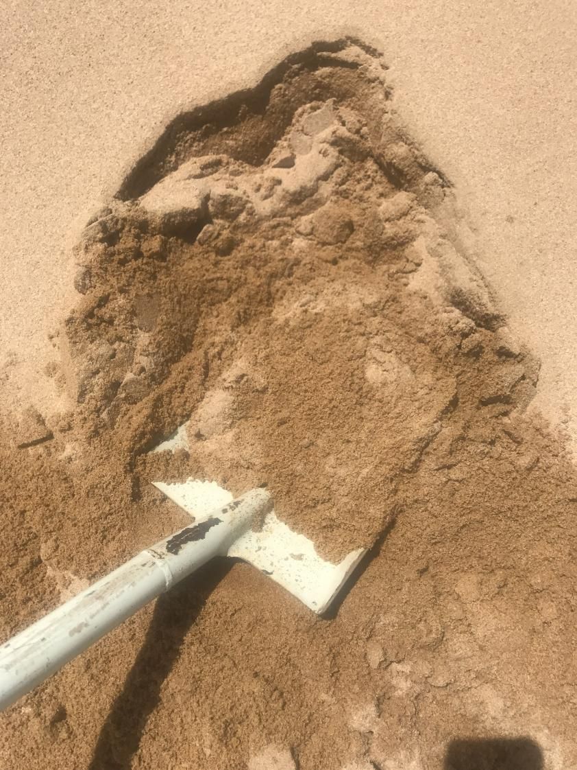 A Shovel is Digging a Hole in the Sand — Chooks Sand And Gravel In Paget, QLD