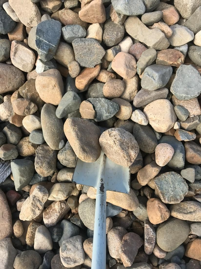 A Shovel is Sitting on Top of a Pile of Rocks — Chooks Sand And Gravel In Paget, QLD