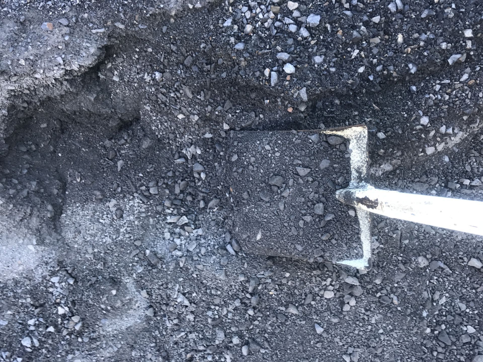 Shovel in Dark Gravel — Chooks Sand And Gravel In Paget, QLD