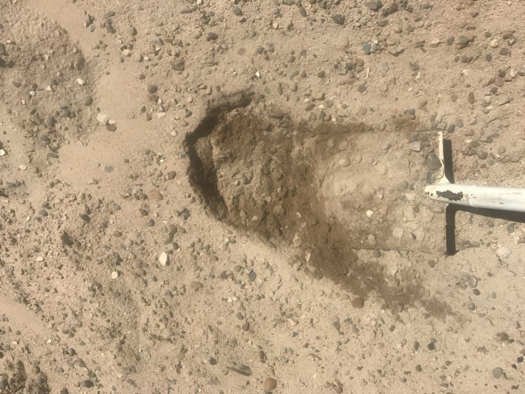 Hole Dug in Sandy Ground; Dark Soil Spills Out Near a White Post — Chooks Sand And Gravel In Paget, QLD