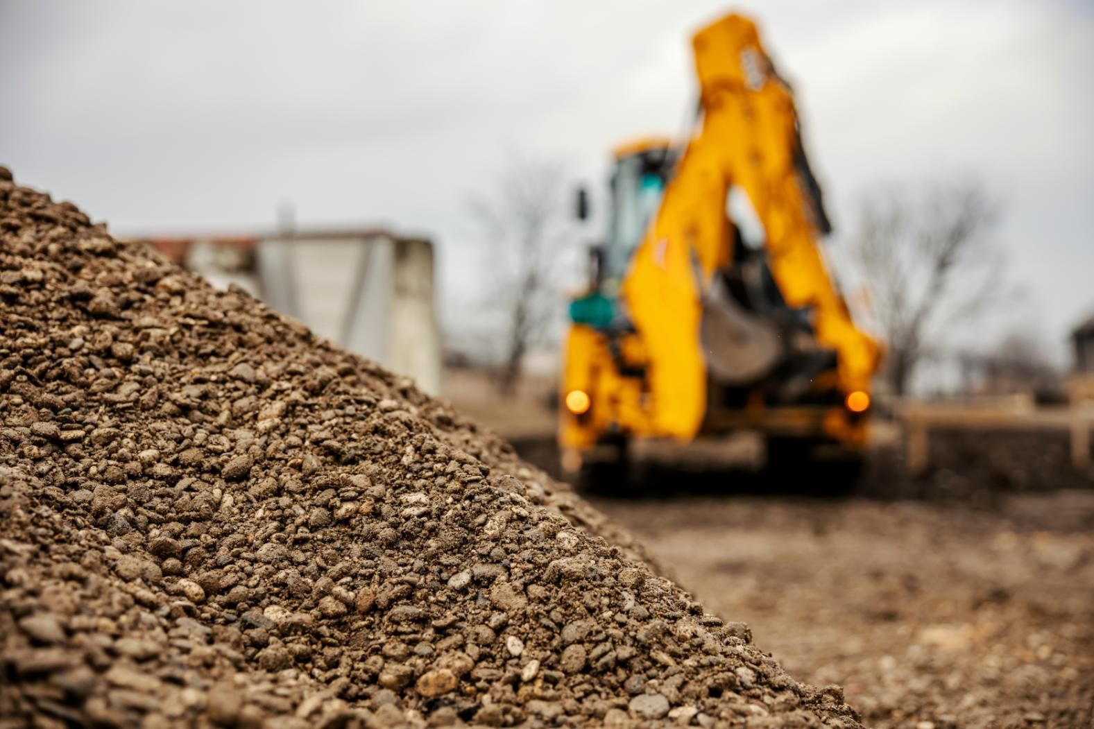 A Pile of Gravel With a Bulldozer in the Background — Chooks Sand And Gravel In Paget, QLD