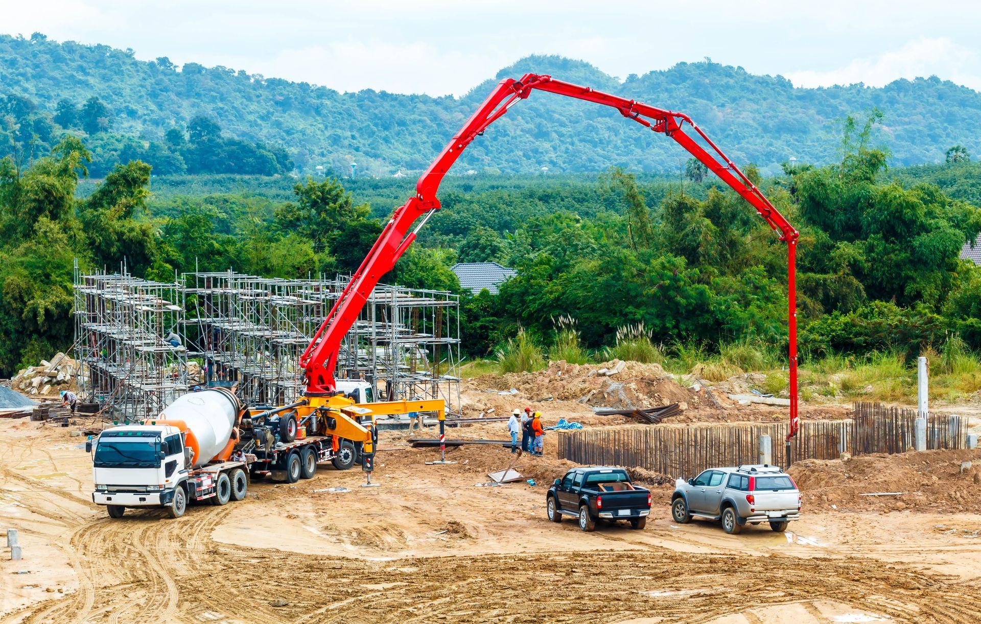 Concrete pumping services at a construction site with a boom pump truck pouring concrete. Concrete pumping services at a construction site with a boom pump truck pouring concrete.