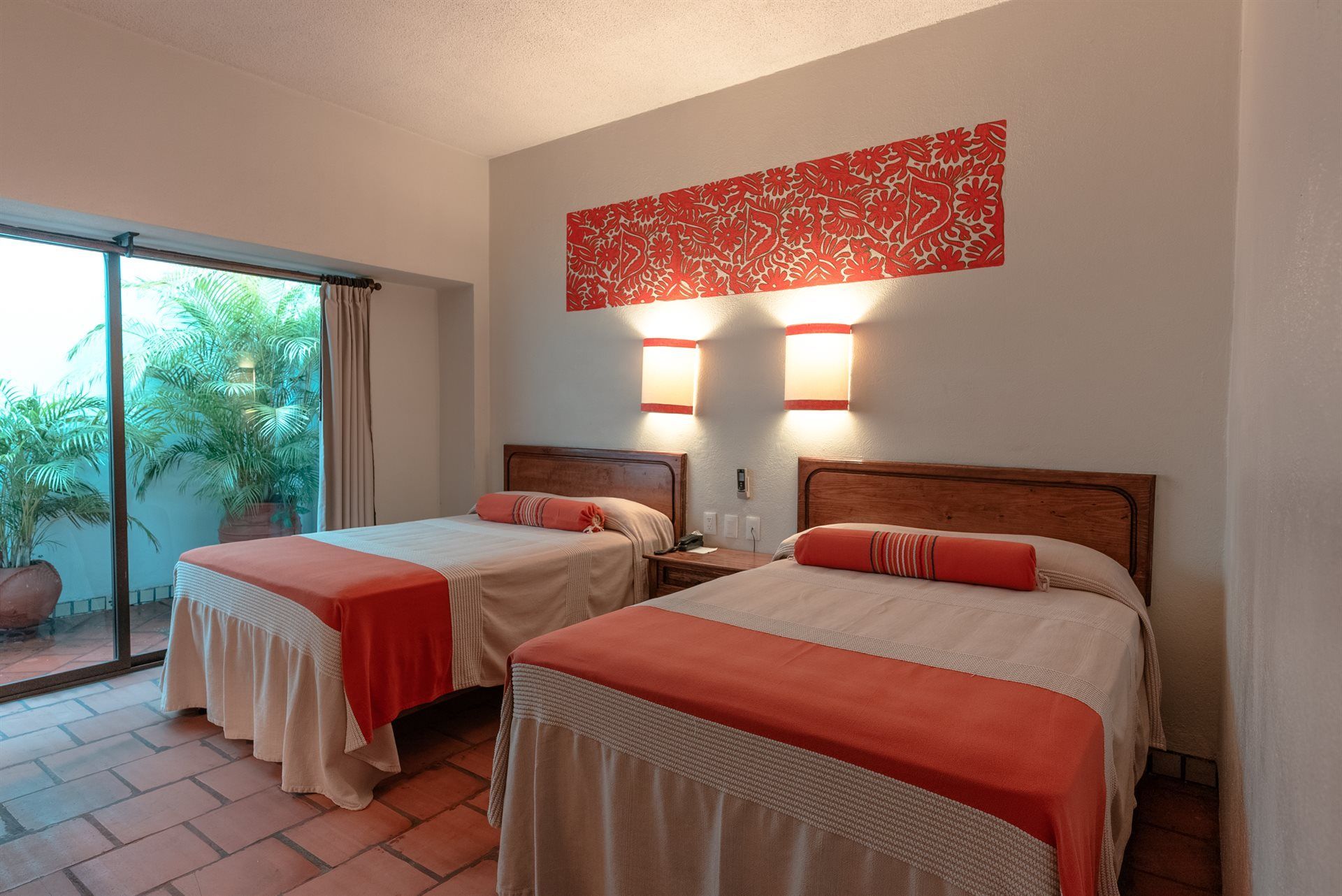 Una habitación de hotel con dos camas y una puerta corrediza de cristal