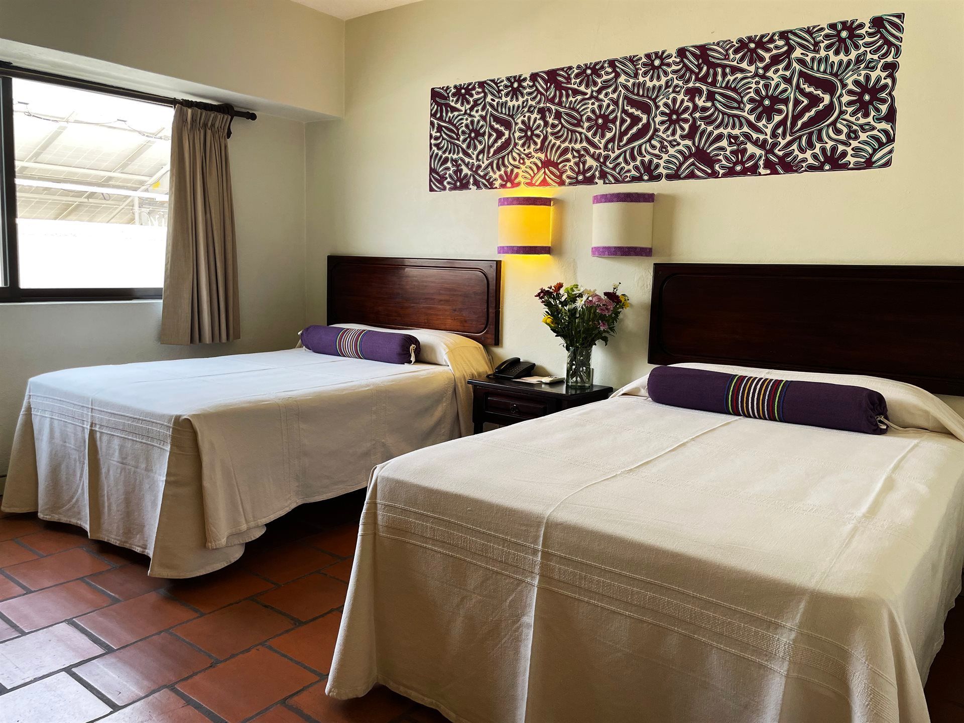 Una habitación de hotel con dos camas y una ventana