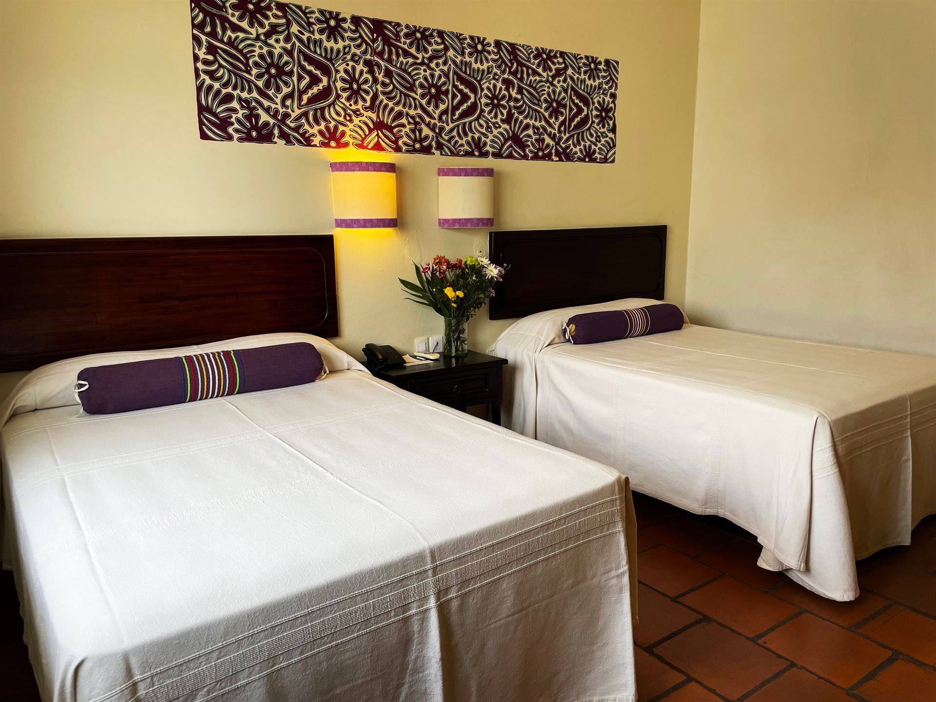 HOTEL PARADOR DEL DOMINICO.Una habitación de hotel con dos camas y almohadas moradas