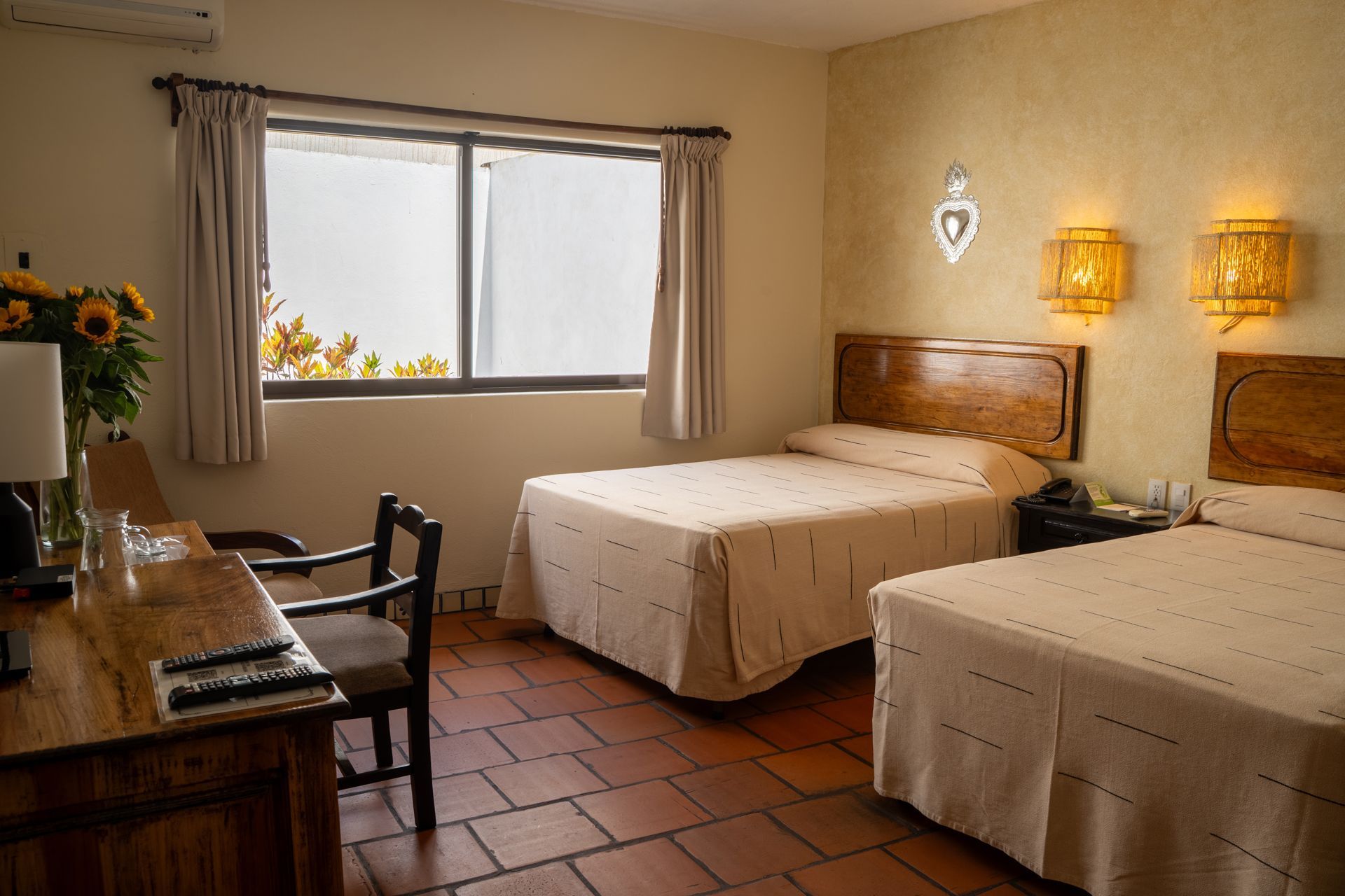 HOTEL PARADOR DEL DOMINICO.Una habitación de hotel con dos camas y almohadas moradas