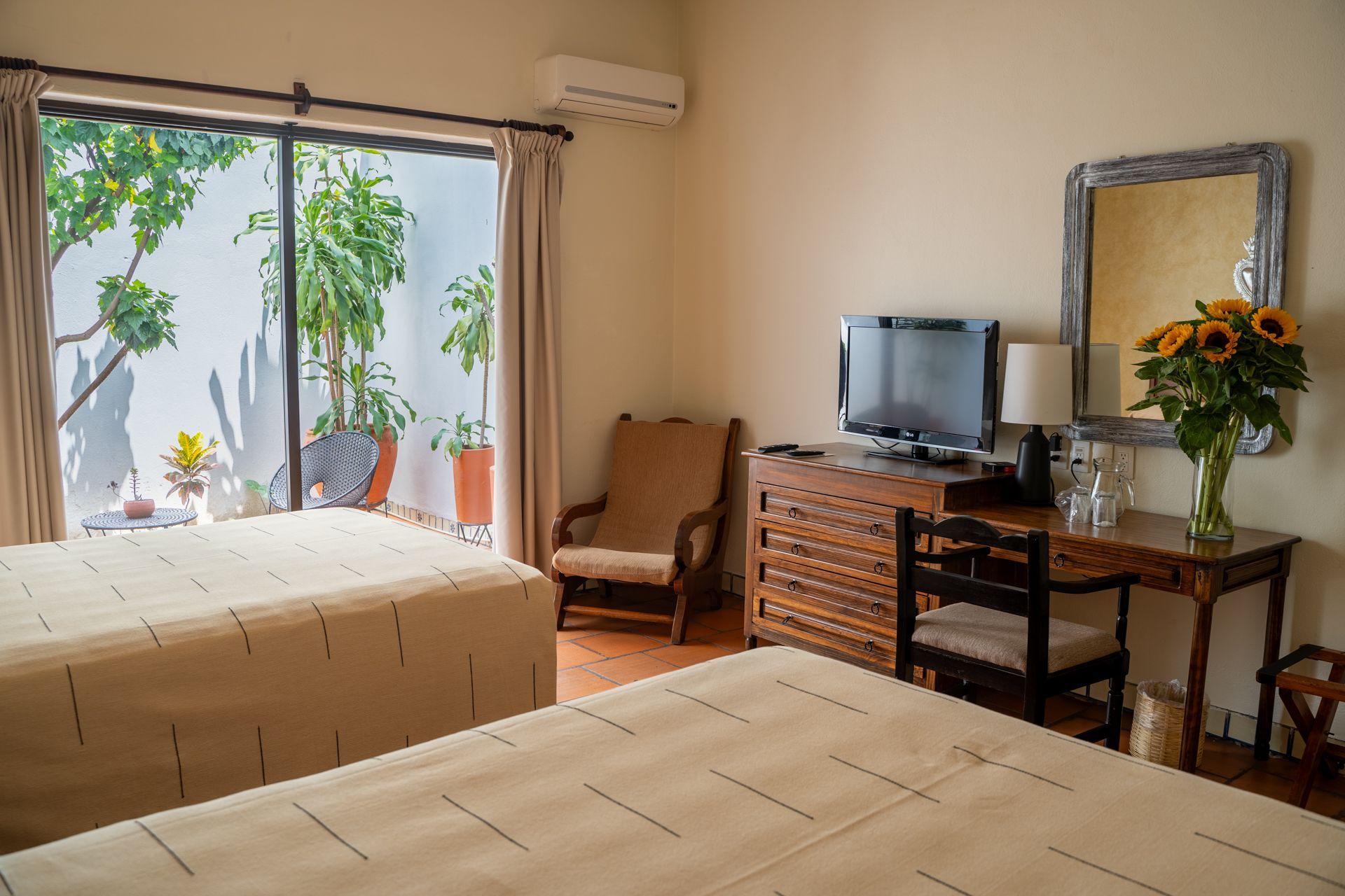 HOTEL PARADOR DEL DOMINICO.Una habitación de hotel con dos camas y una puerta corrediza de cristal