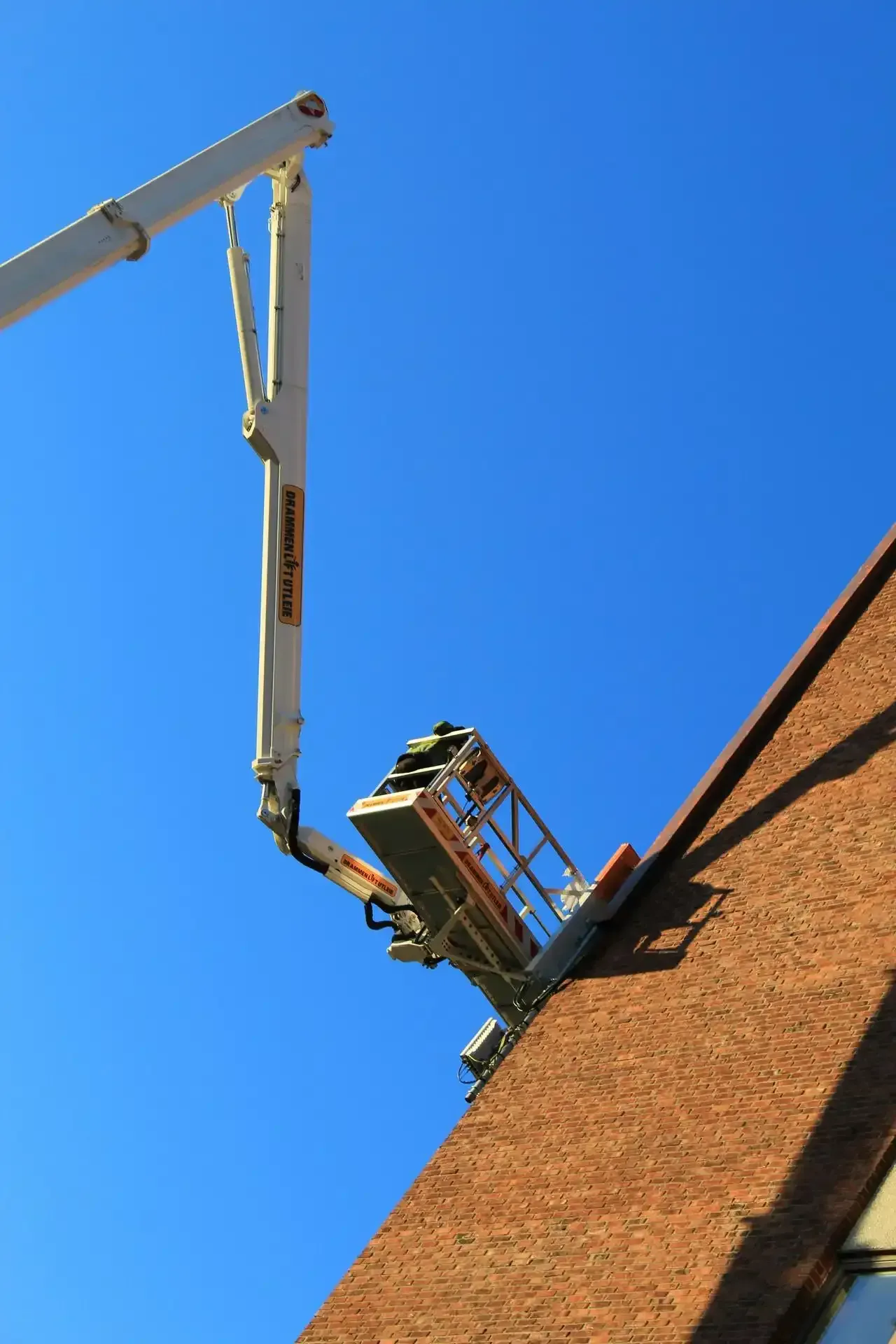 A Boom Lift with a Basket on a Roof A Boom Lift with a Basket on a Roof