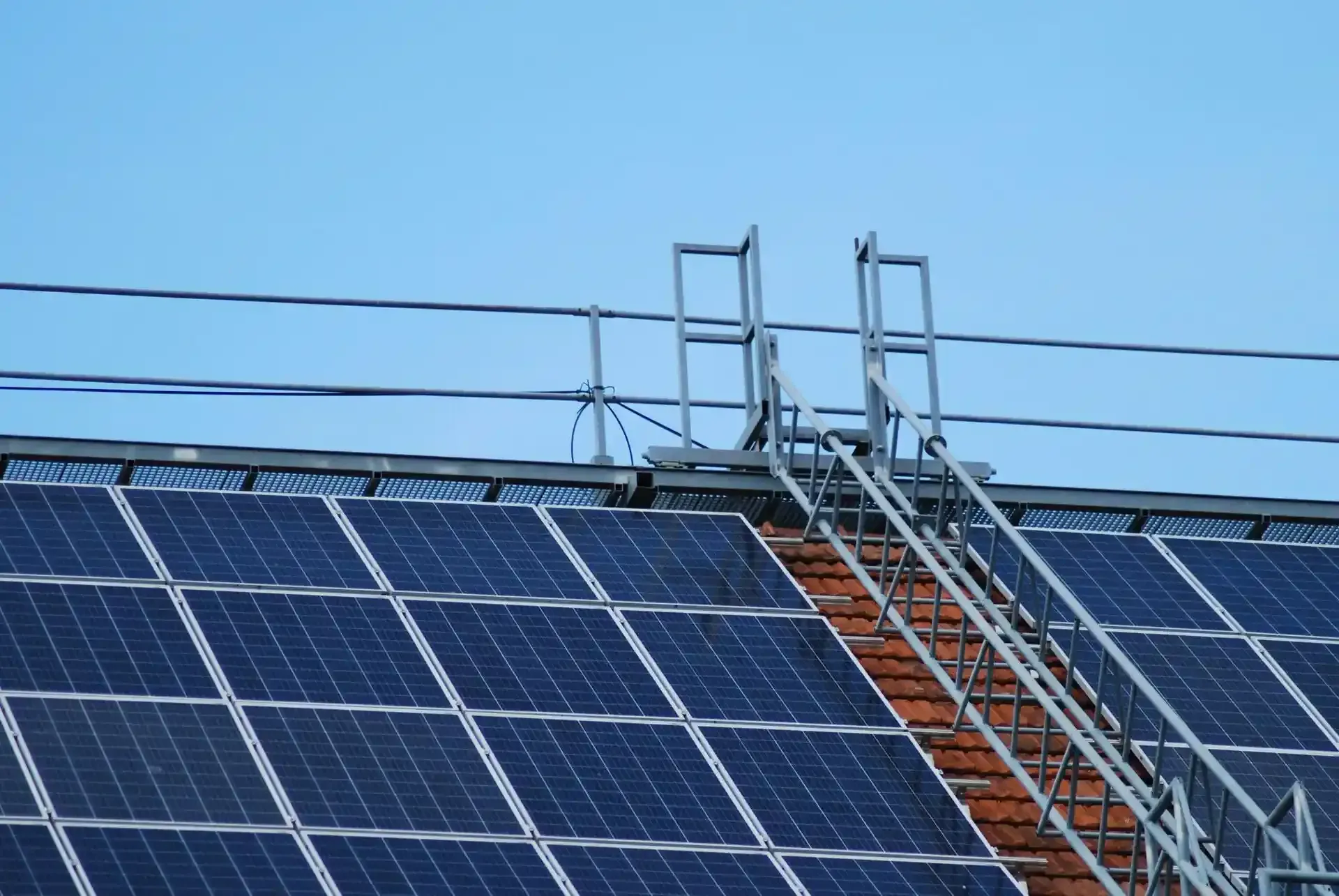 Solar Panels on a Roof with a Metal Ladder Leading to a Platform Solar Panels on a Roof with a Metal Ladder Leading to a Platform