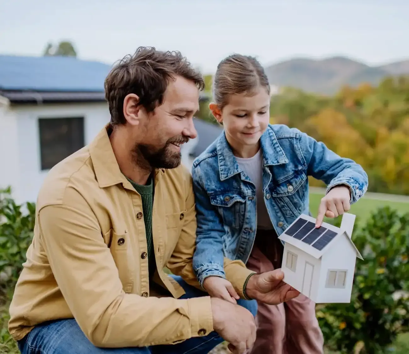 Father and Daughter Checking the House Model with Solar Panels