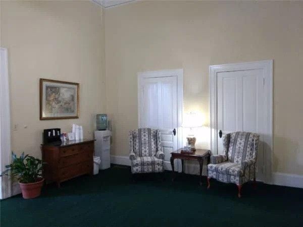 A living room with two chairs and a dresser