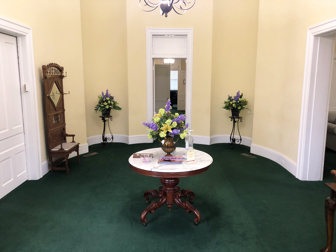 There is a table with flowers on it in the middle of the room.