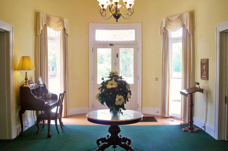 A table with a vase of flowers on it in a hallway