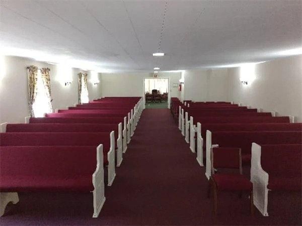 Rows of red benches in an empty church