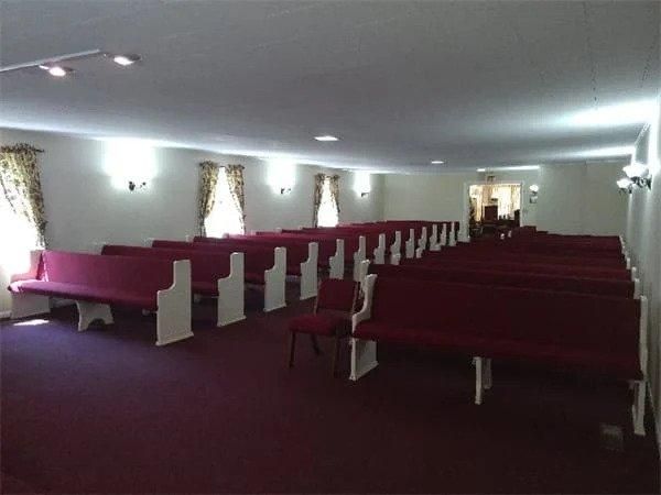 An empty church with red benches and chairs