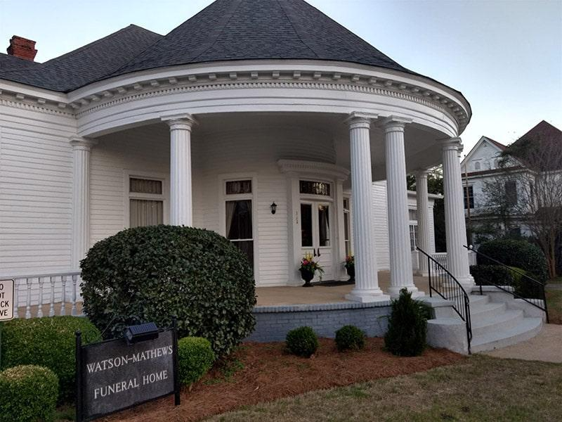 A funeral home with a sign in front of it