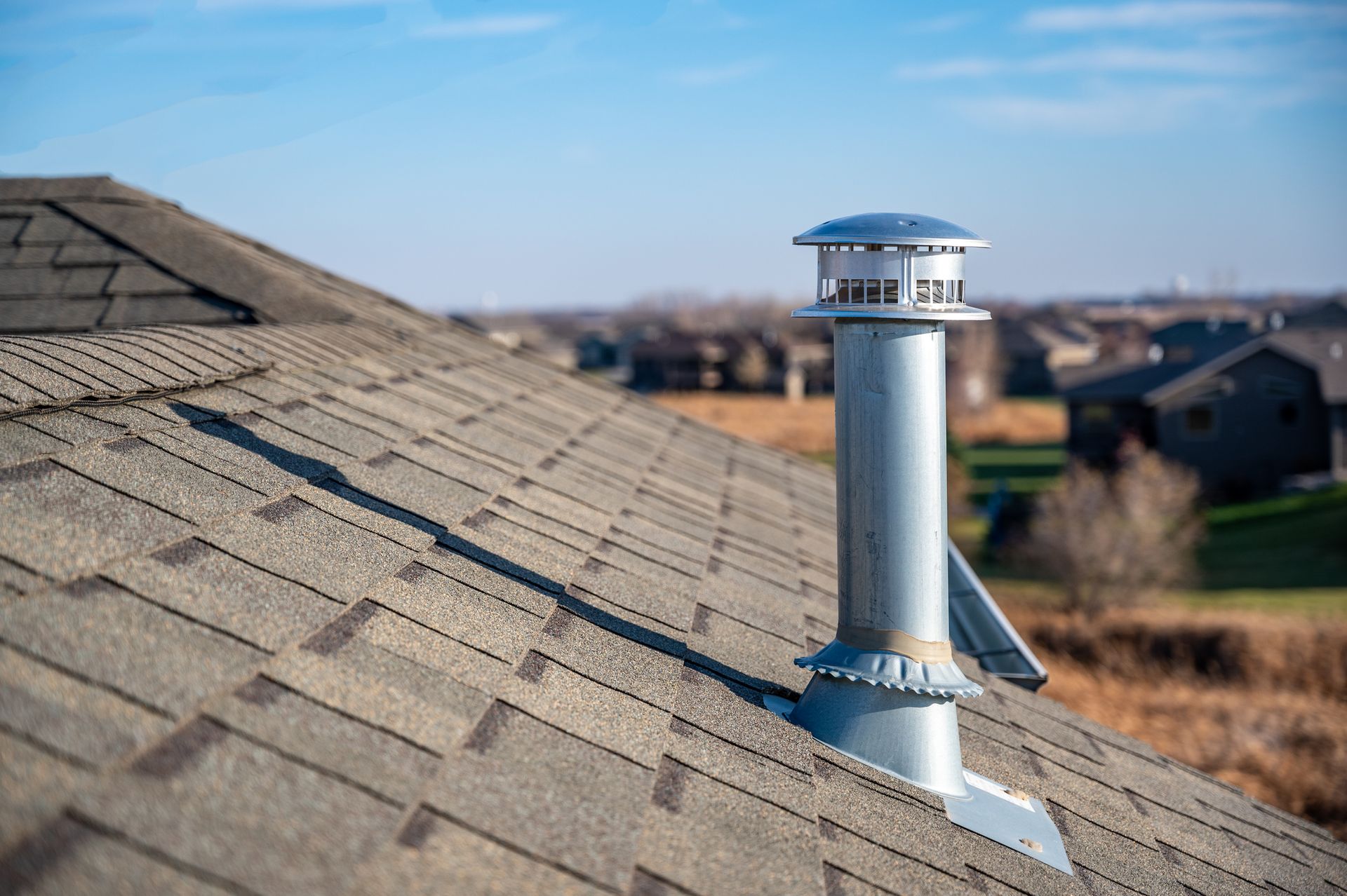There is a chimney on the roof of a house.