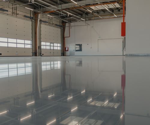 A large empty warehouse with a shiny concrete floor