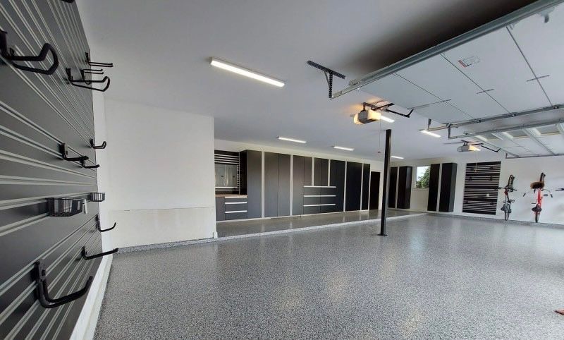 A large empty garage with lots of cabinets and hooks on the wall.