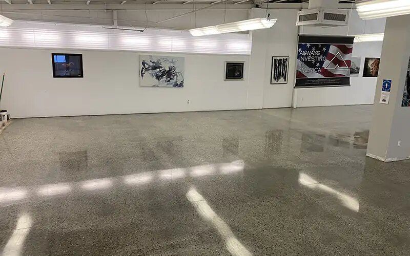 A large empty room with a flag on the wall.