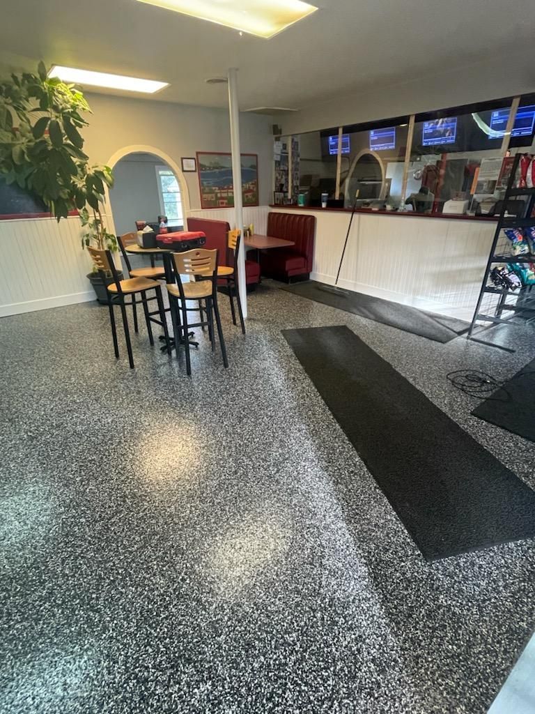 A restaurant with tables and chairs in a garage floor.