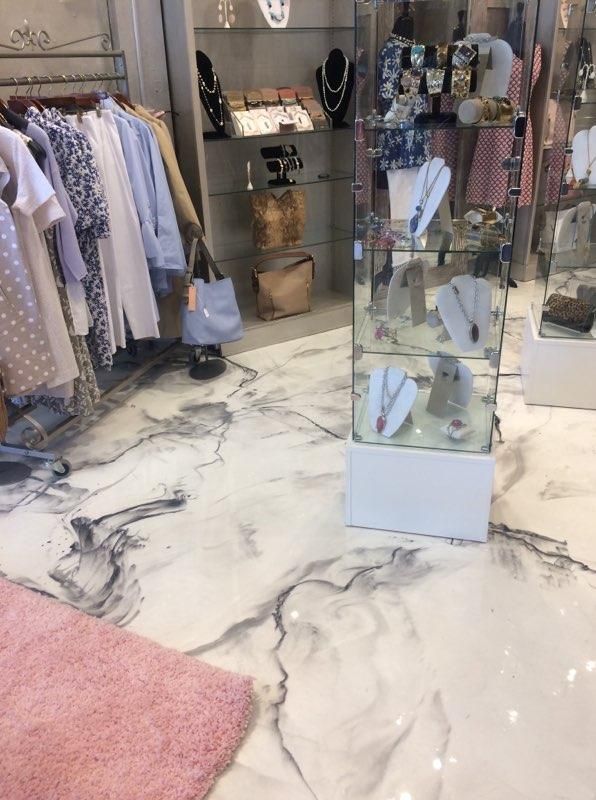 A store with a marble floor and clothes on display