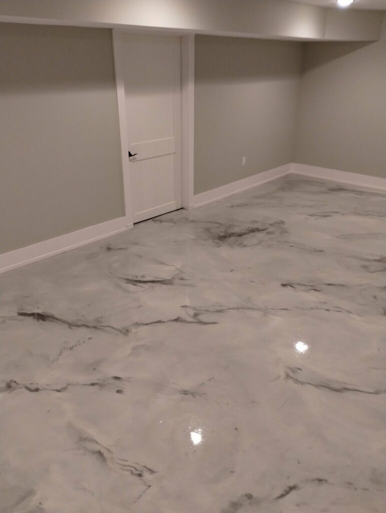 A basement with a marble floor and a door.