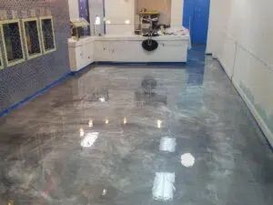 A room with a shiny metallic floor and a counter.