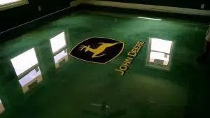 A green floor with a john deere logo on it.