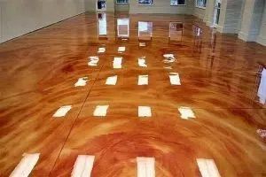 A room with a shiny metallic floor and a lot of windows.