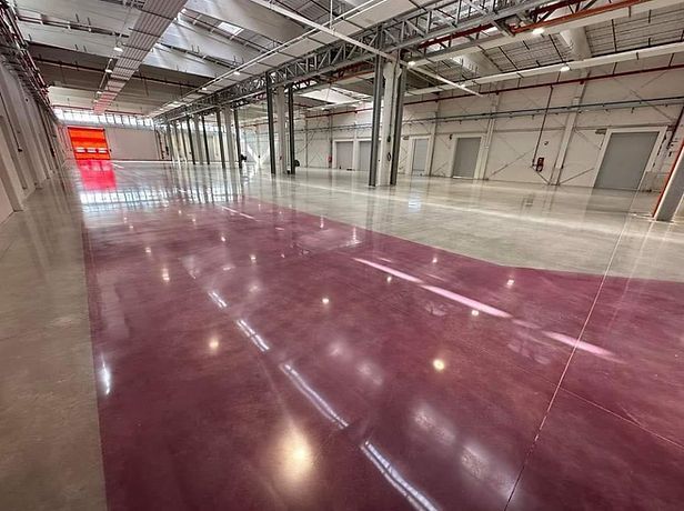 A large warehouse with a purple floor and white walls.