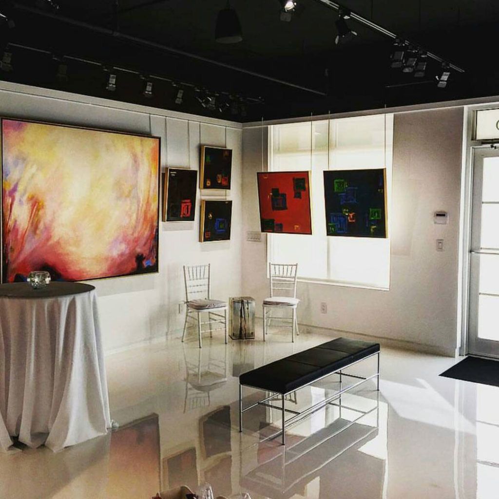 A room with a table and chairs and paintings on the wall