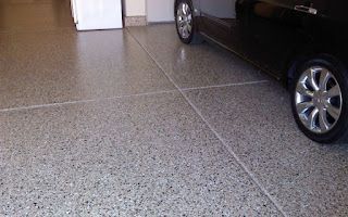 A car is parked in a garage with a concrete floor.