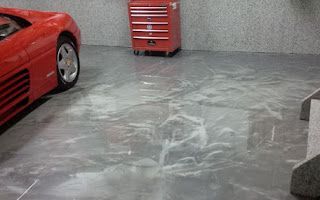 A red sports car is parked in a garage.