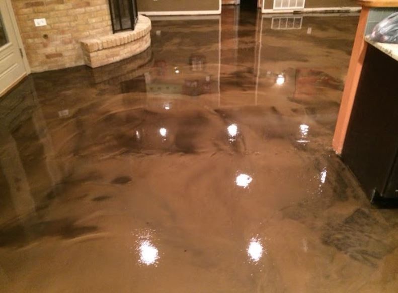 A shiny concrete floor in a living room with a fireplace.