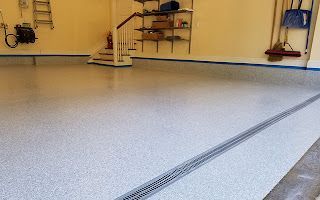 A garage with a concrete floor and stairs.