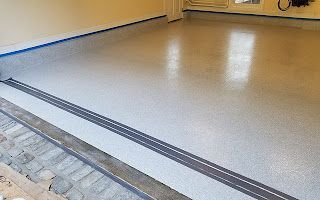 A garage floor with a gray and blue stripe on it.