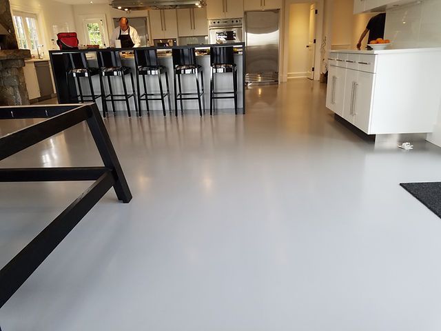 A kitchen with a white floor and black stools