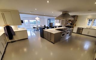 A large kitchen with stainless steel appliances and white cabinets.