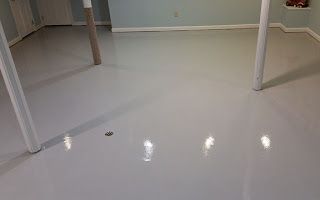 A basement with a white epoxy floor and white walls.