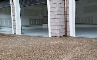 A garage with a concrete floor and a brick wall.