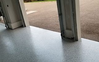 A close up of a garage floor with a garage door open.