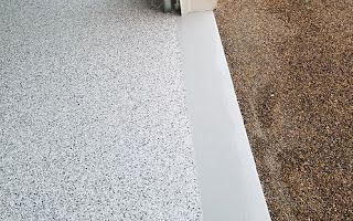 A close up of a white floor next to a brown carpet.