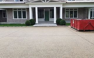 A large house with a red dumpster in front of it.